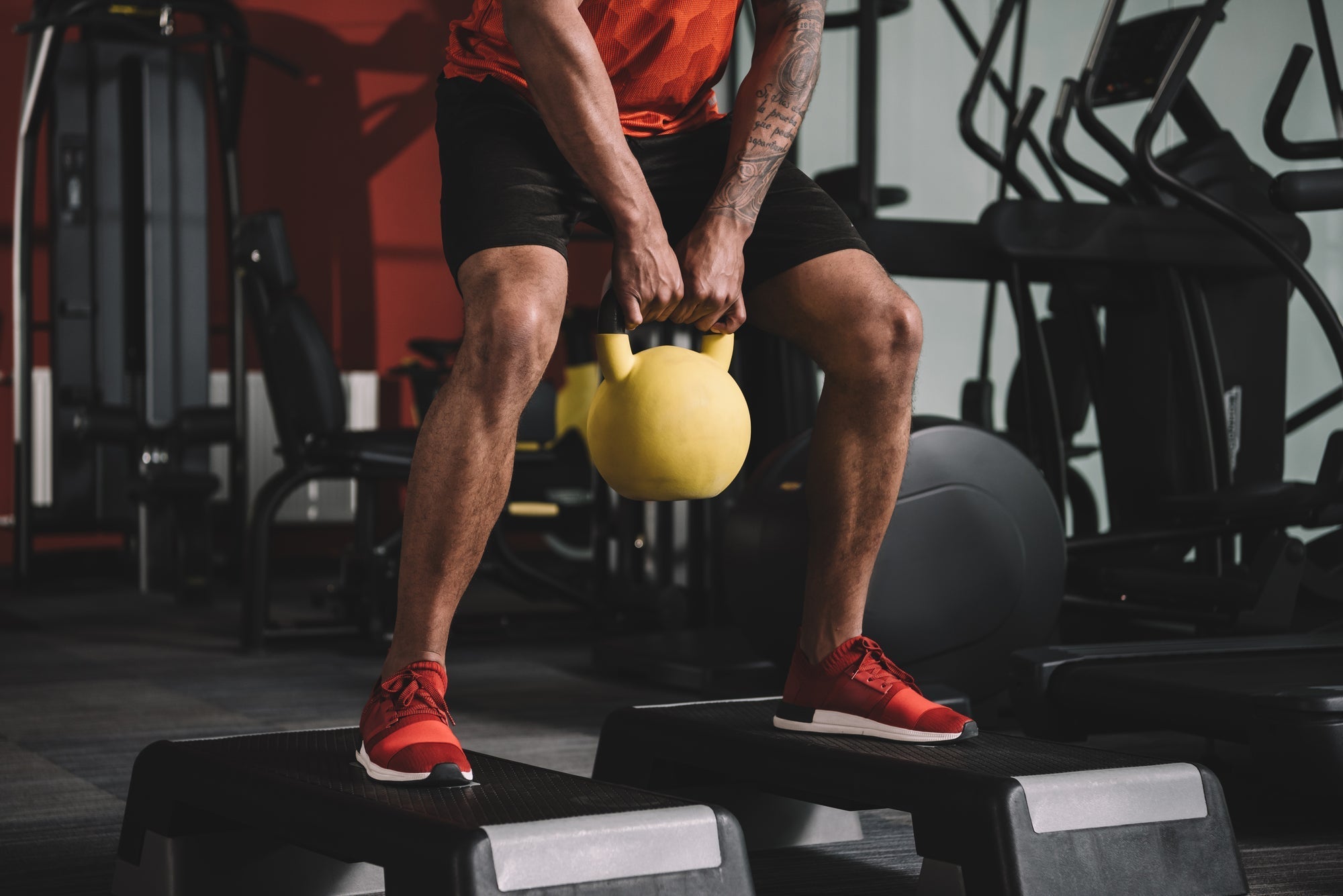 fit young woman working out with kettlebell in industrial gym