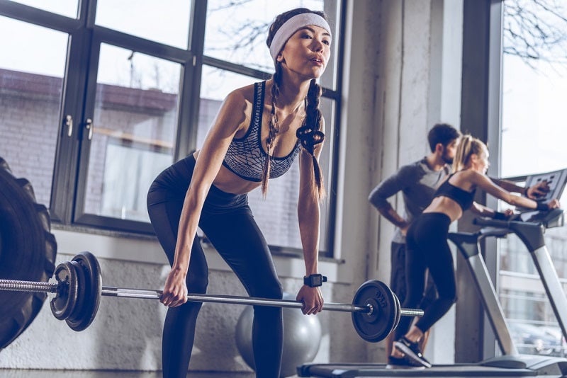 Woman lifting barbell in a gym