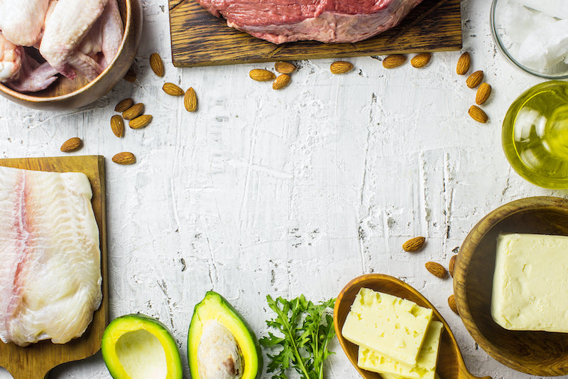 Alimentos aptos para la dieta cetogénica, como aguacate y carne cruda, sobre una mesa